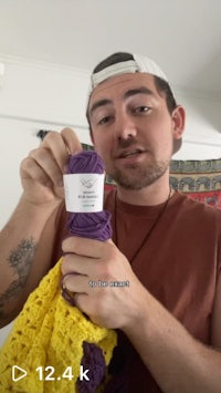 a man holding up a piece of yarn